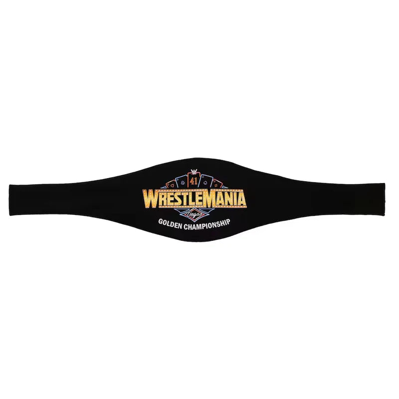 A black WrestleMania Golden Championship belt laid flat against a white background, featuring gold, blue, and white embroidered details.