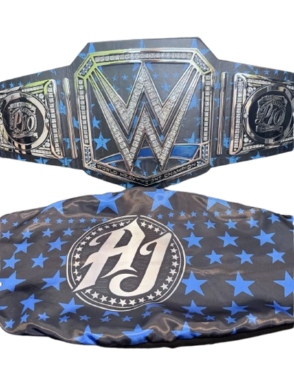 A wrestling championship belt and matching headband set. The belt features a large central silver 'W' with 'Wrestling Entertainment' text, flanked by two side plates with 'W' and 'AJ' logos, all over a black background with blue stars.