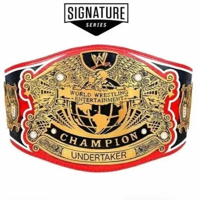 A WWE Undertaker Championship belt from the Signature Series, featuring a large gold-plated central plate with black and white lettering, flanked by red and black straps with white accents.