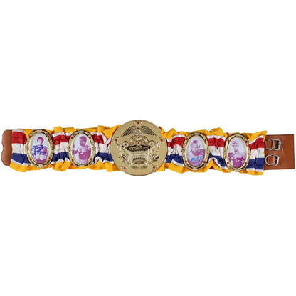 A traditional Thai royal belt (Sampao) featuring a gold-colored central plaque with a royal crest, flanked by four oval plaques with portraits of royal children, all mounted on a yellow, red, and white striped fabric strap with a brown leather end.