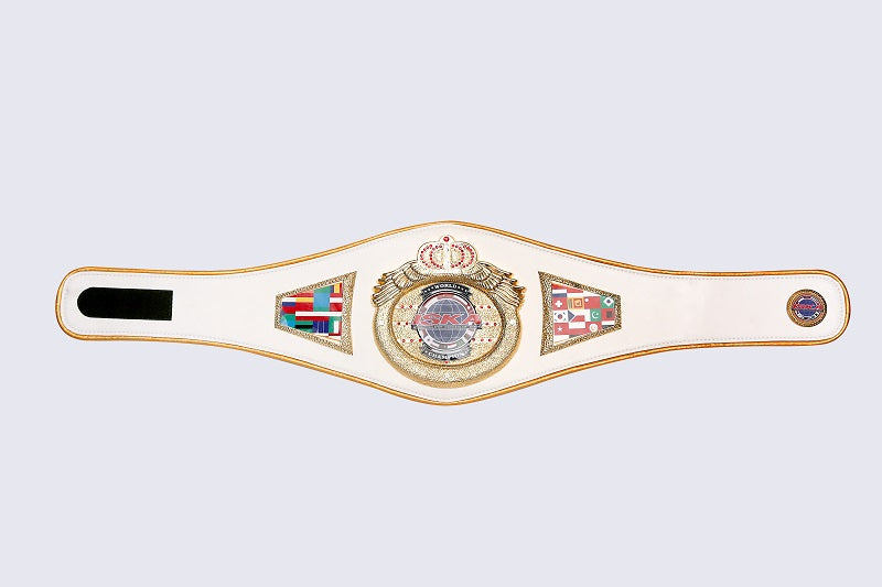 A white and gold boxing championship belt with a central crown emblem, side flags, and a black rectangular insert on a light gray background.