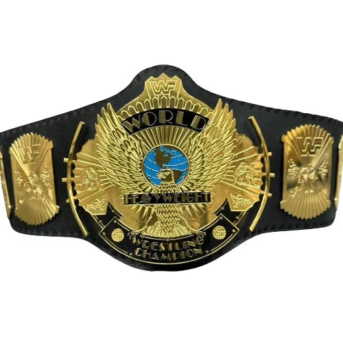 Black and gold wrestling championship belt with prominent logo on a white background