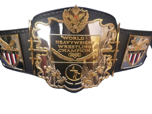A championship wrestling belt with a large polished gold central plate engraved 'WORLD HEAVYWEIGHT WRESTLING CHAMPION' and ornate gold detailing, mounted on a black strap with side panels featuring eagle and shield emblems.