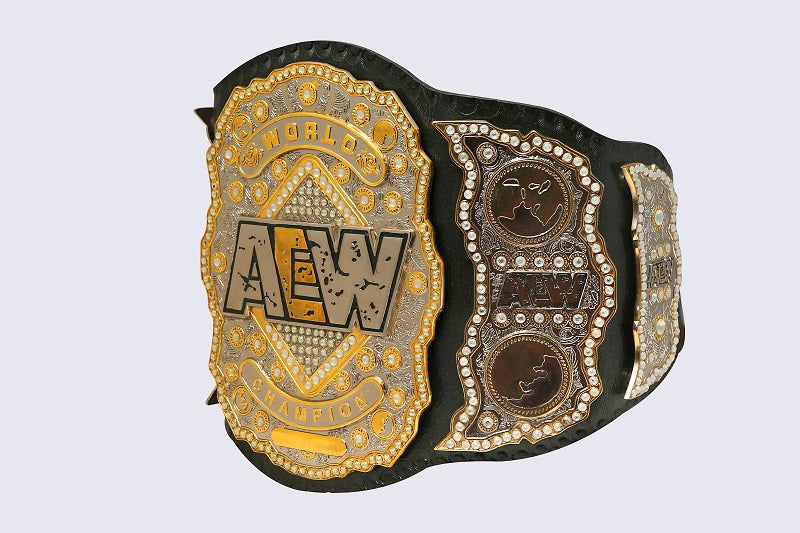 An AEW World Championship belt with ornate gold and silver metal plates, black leather strap, and small clear rhinestone accents, shown on a light gray background.