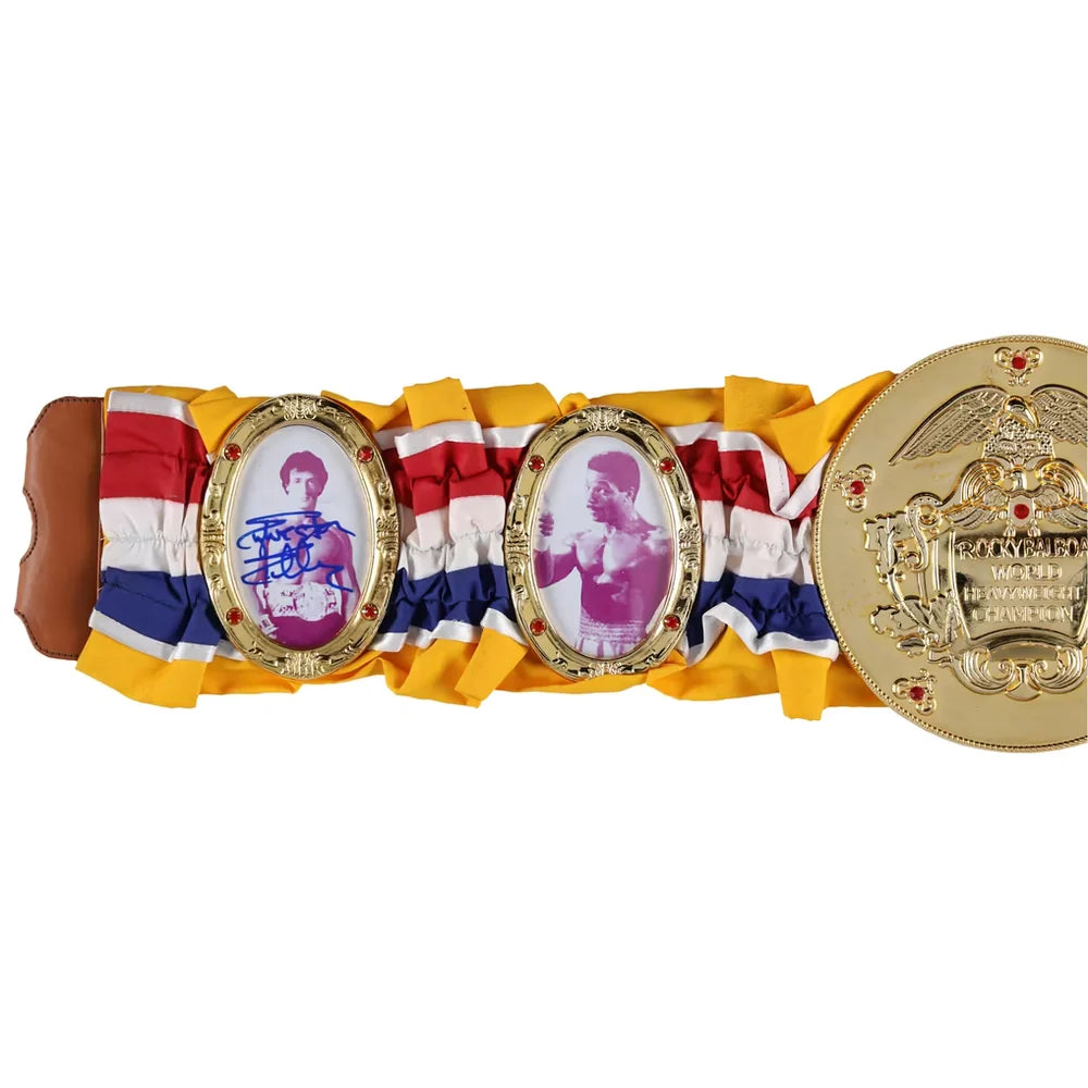 A replica or commemorative championship belt featuring a yellow, red, and blue striped fabric base, two oval gold-tone plates with printed boxer portraits, one signed in blue ink, and a large circular gold-tone end plate on a white background.