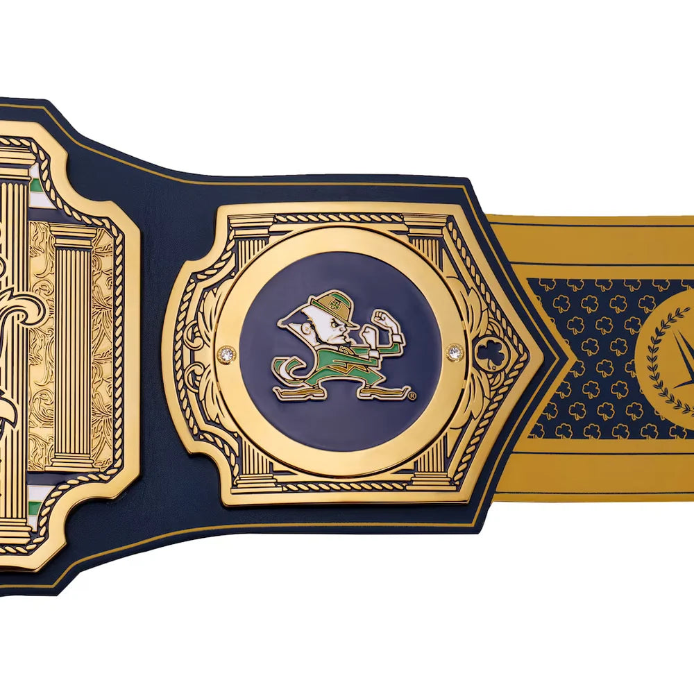 A close-up of a championship-style belt or strap featuring a large central gold-toned medallion with a navy blue circular inset and a green-and-white leprechaun figure. The surrounding sections are navy blue with ornate gold detailing and a gold side panel.