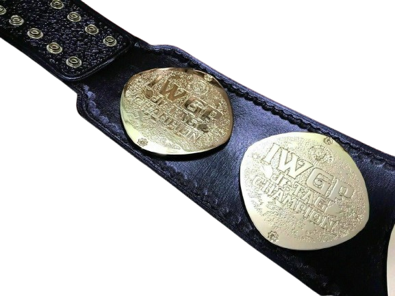 A close-up of a black leather wrestling championship belt with two large gold-toned metal plates engraved with 'IWGP United States Championship'.