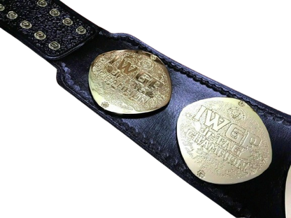 A close-up of a black leather wrestling championship belt with two large gold-toned metal plates engraved with 'IWGP United States Championship'.