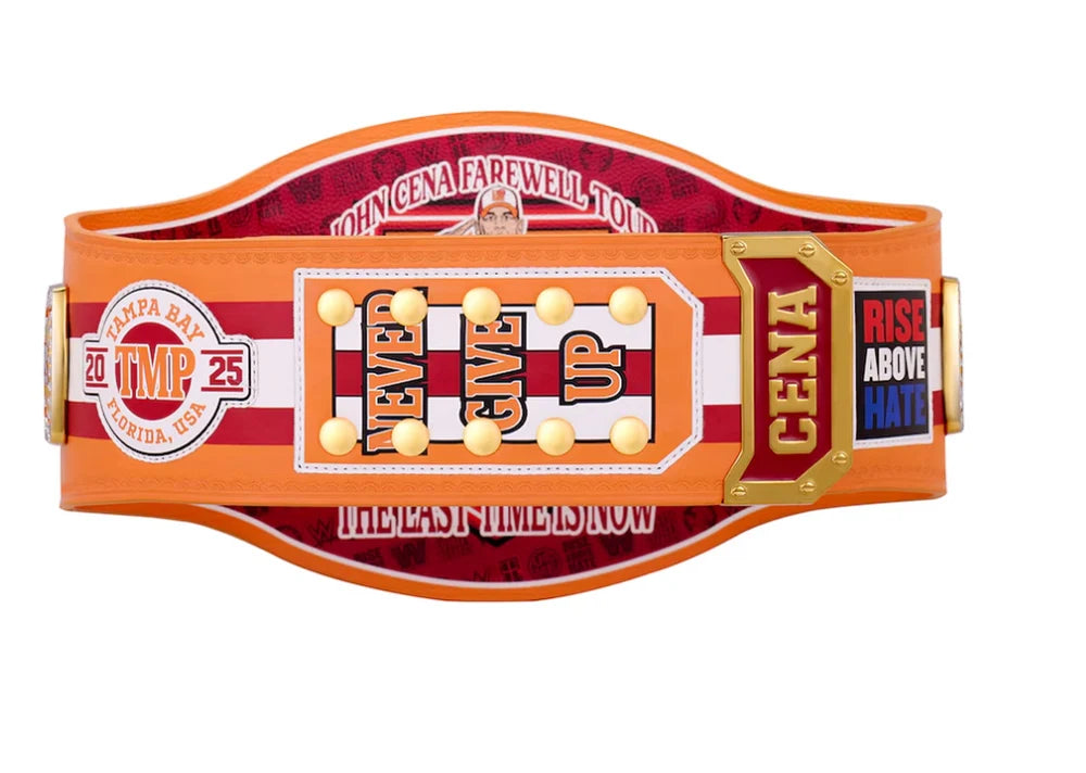 A WWE championship belt with a black strap and a large central gold, silver, and red plate, flanked by two smaller gold and silver plates, shown on a plain white background.