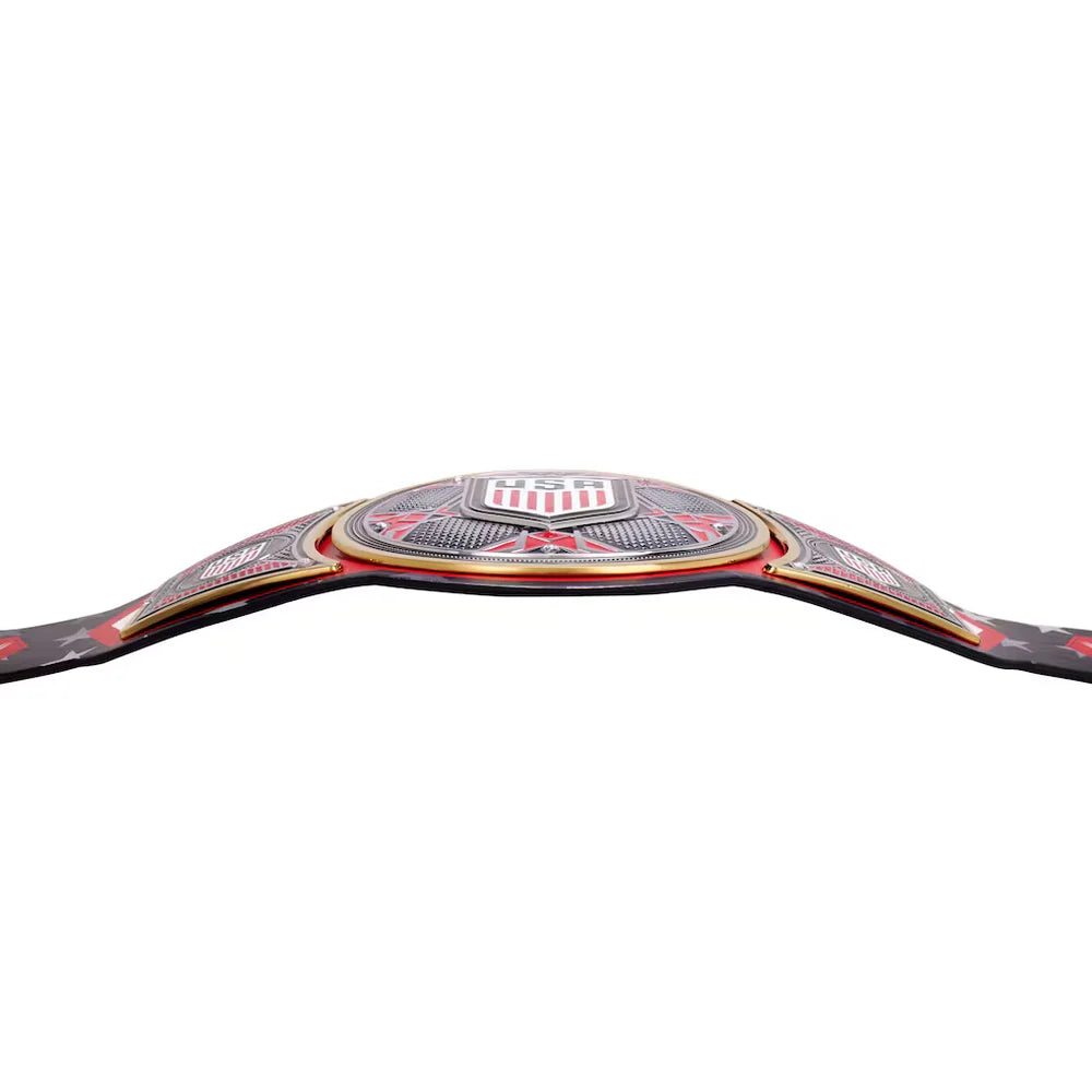 A close-up of a championship belt buckle with red, white, and black detailing, shown against a plain white background.