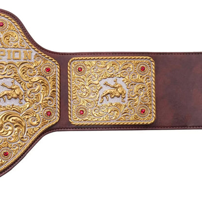 Close-up of a championship belt with intricate designs and red stones on a white background