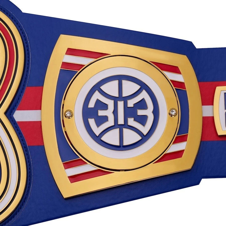 Close-up of a championship belt with a prominent emblem on a white background