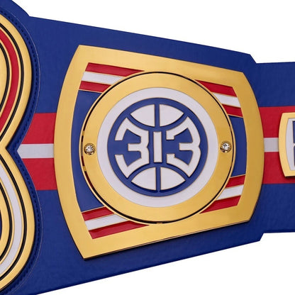 Close-up of a championship belt with a prominent emblem on a white background