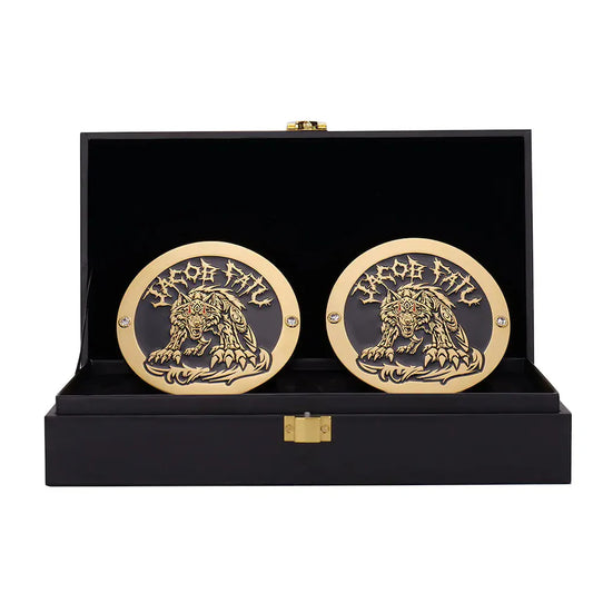 Pair of gold and black medallions with a lion design in a black display case.