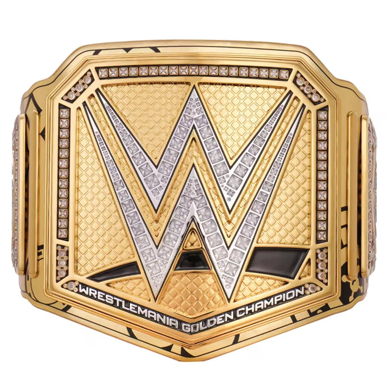 WrestleMania Golden Championship belt featuring a large gold-toned plate with a silver and gold WWE 'W' logo, bordered by clear gemstones, and the text 'WRESTLEMANIA GOLDEN CHAMPION' along the bottom.