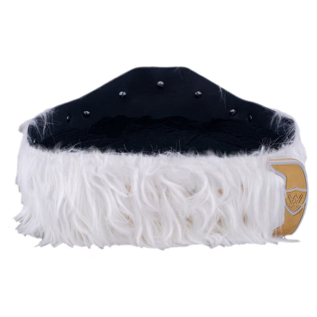 A black and white faux fur skullcap with silver studs on the top and a gold shield emblem on the side, shown against a plain white background.
