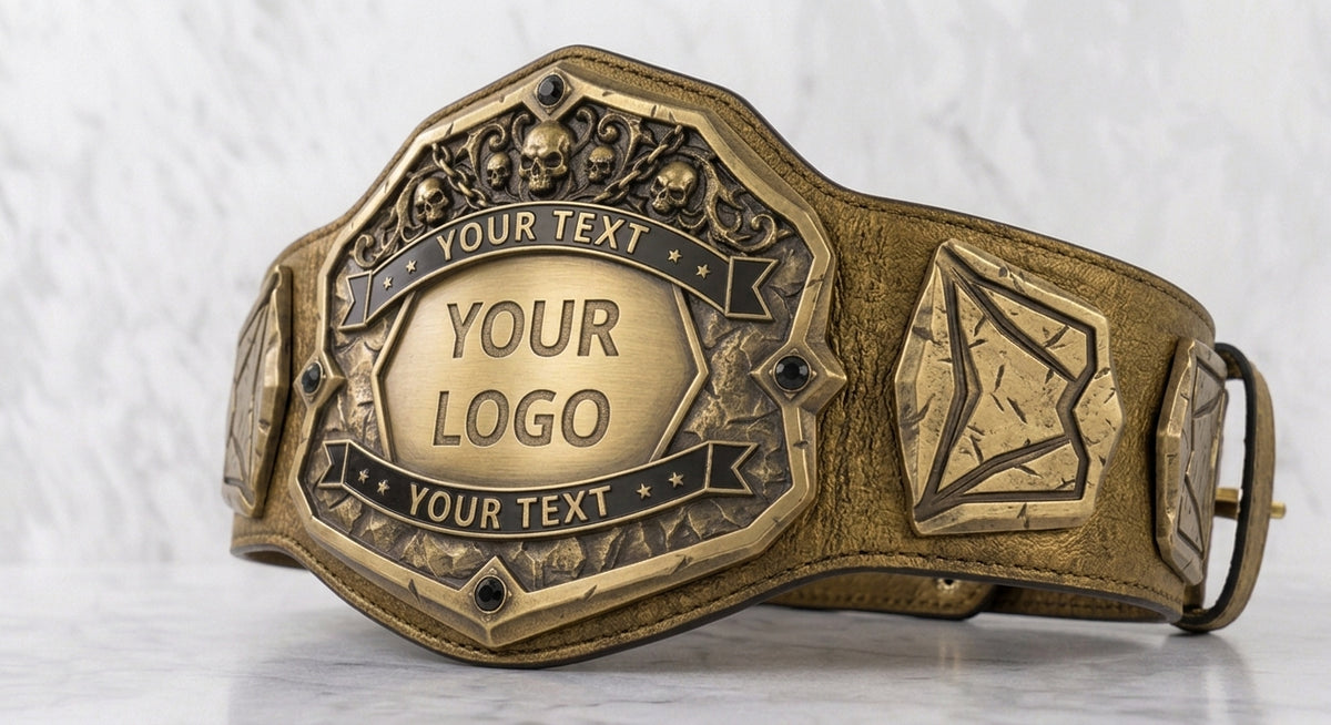 A customizable bronze championship-style belt with an ornate central plaque, decorative scrollwork, and a side shield motif, shown on a light marble surface against a white marble background.
