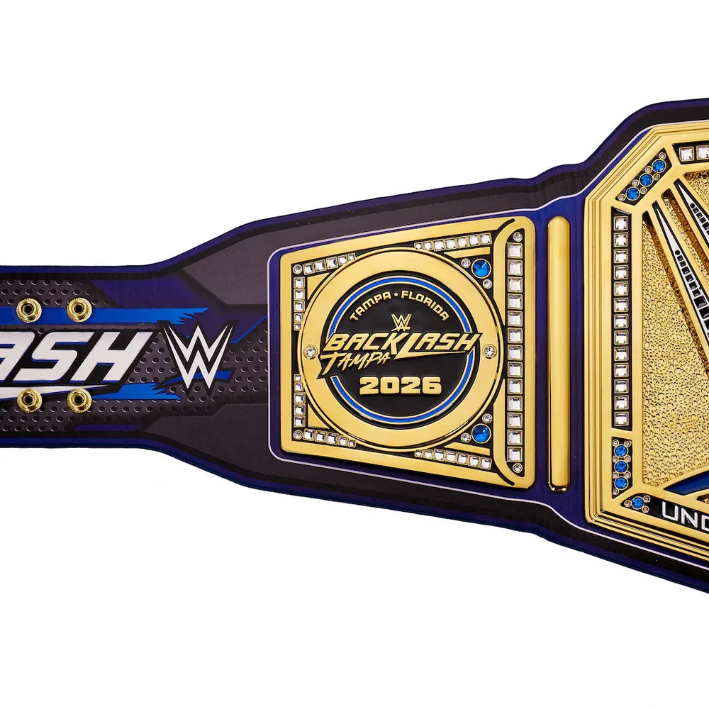 A close-up of a WWE Backlash Tampa 2026 championship belt against a white background, showing the gold central plate, blue and black strap details, and WWE branding.