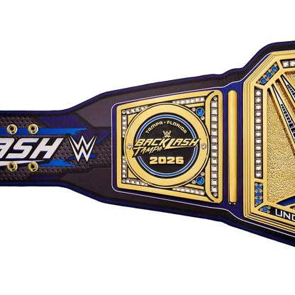 A close-up of a WWE Backlash Tampa 2026 championship belt against a white background, showing the gold central plate, blue and black strap details, and WWE branding.