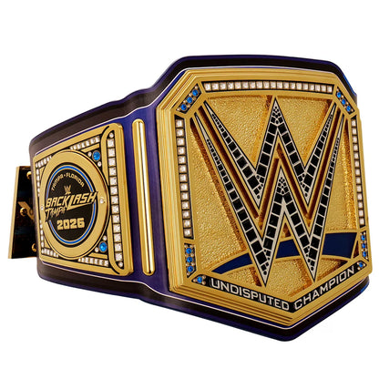 A WWE Undisputed Champion belt with a gold and purple design, featuring a large 'W' logo on the front plate and a circular 'Back in the Main Event 2025' medallion on the side, shown on a white background.