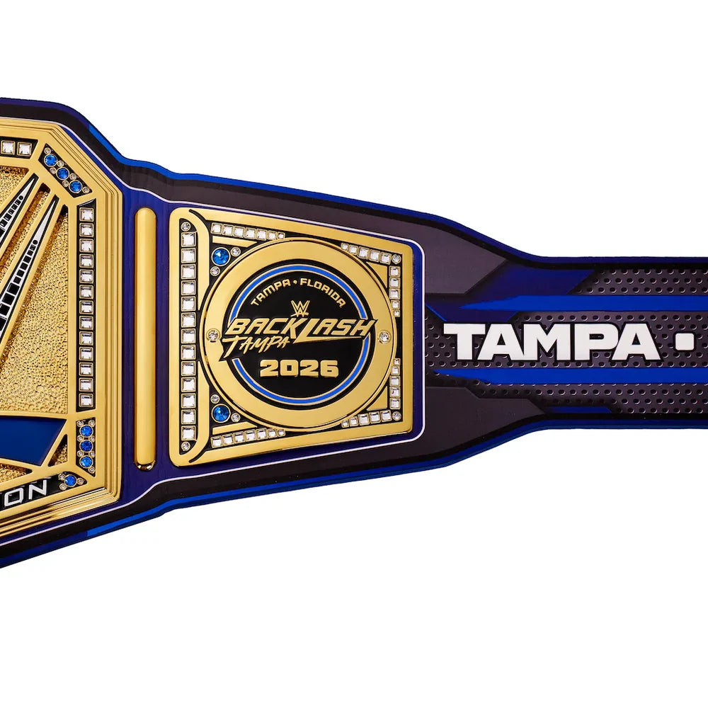 WrestleMania 2026 Backlash Tampa belt featuring a gold and blue design with white lettering on a black textured strap, shown against a plain white background.