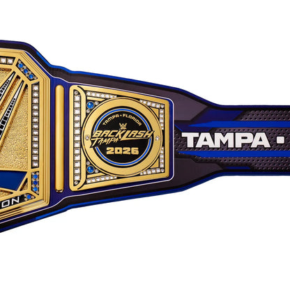 WrestleMania 2026 Backlash Tampa belt featuring a gold and blue design with white lettering on a black textured strap, shown against a plain white background.