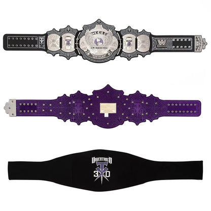Three wrestling championship belts and a black undershirt with a white and purple 'Undying Battle 3x3' graphic, displayed against a solid white background.