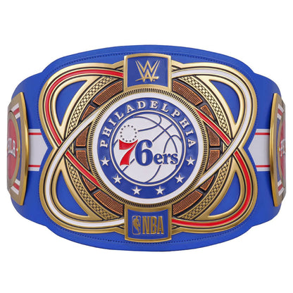 A replica Philadelphia 76ers WWE championship belt featuring a royal blue leather strap with ornate gold, red, and white metal-style plates. The center plate displays the Philadelphia 76ers logo with WWE branding at the top and an NBA logo at the bottom.