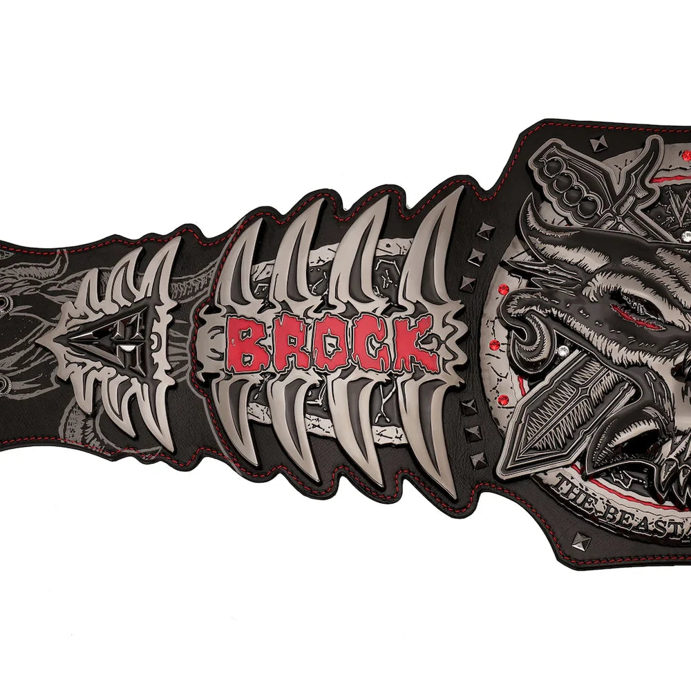 A close-up of a black leather belt featuring a large, detailed silver and red metal buckle with the name 'BROCK' in red letters and a wolf head design on the right side.