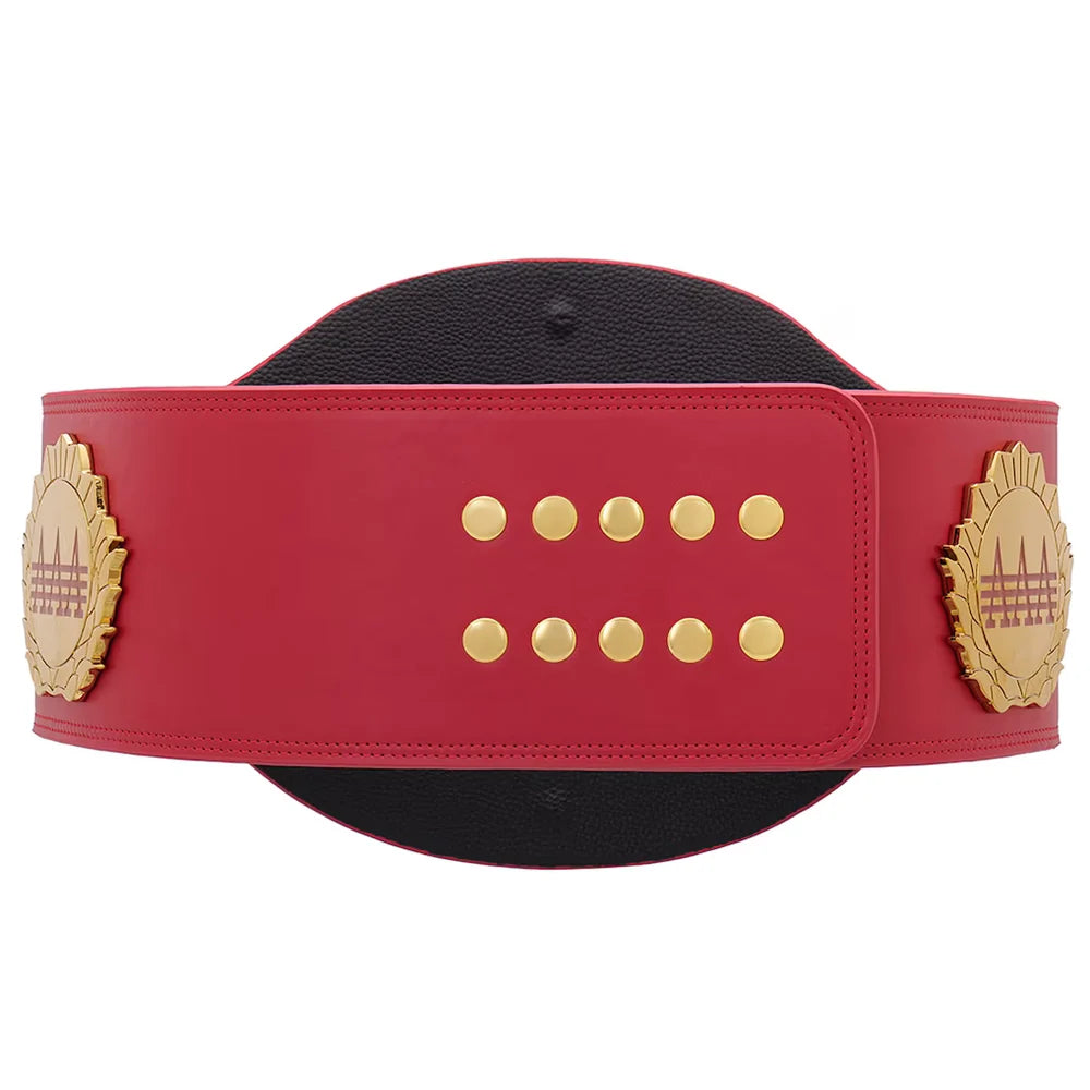 A red faux-leather championship belt with gold-tone hardware, featuring a black textured center insert and two ornate gold side plates with a cityscape design.