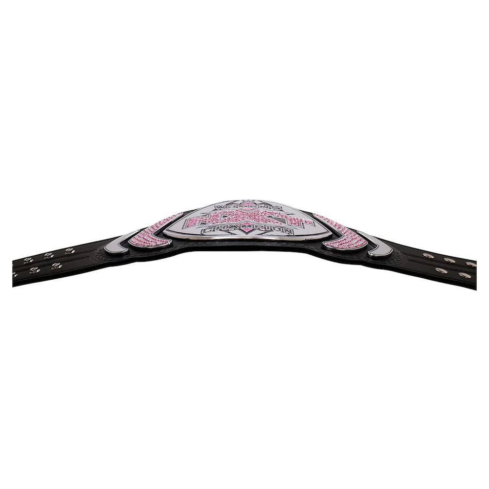 A championship-style belt with a black strap and a central silver-toned plate embellished with pink rhinestones and white lettering, shown against a plain white background.