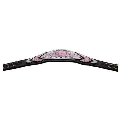 A championship-style belt with a black strap and a central silver-toned plate embellished with pink rhinestones and white lettering, shown against a plain white background.