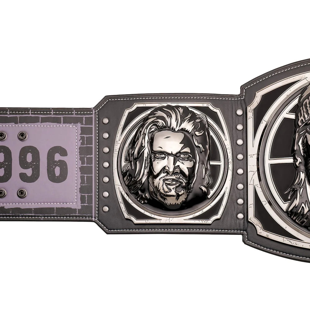 A close-up of a championship-style belt featuring a large engraved metal plate with a portrait, a second engraved plate, and a light purple strap section with the number 096.
