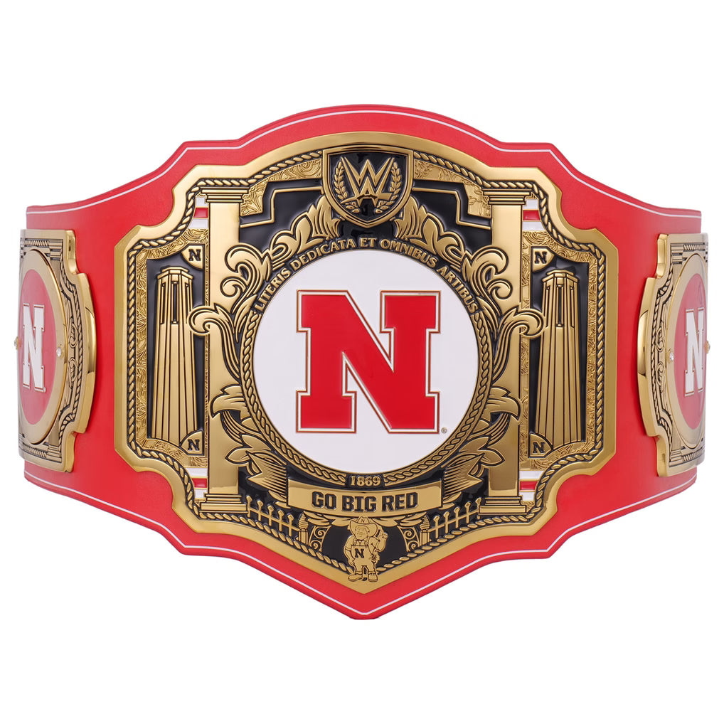 A red and gold WWE championship belt featuring a large central gold plaque with a red 'N' on a white background, flanked by red side plates with gold details, shown on a plain white background.