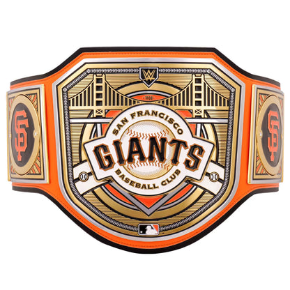 San Francisco Giants baseball club championship belt featuring an ornate gold and white central plaque with the team name, bridge illustration, and San Francisco skyline details, bordered by bright orange straps with orange and black SF logos on the sides.