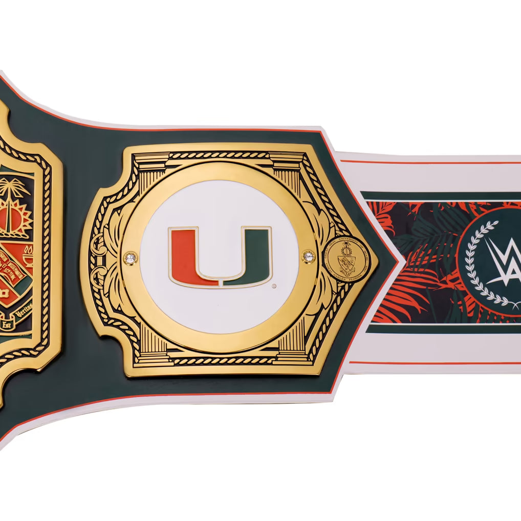 A close-up of a decorative championship-style belt or strap featuring a large gold-toned central plate with a red and green Miami-style 'U' logo on a white center, bordered by dark green and red sections, plus WWE branding visible on the right side.