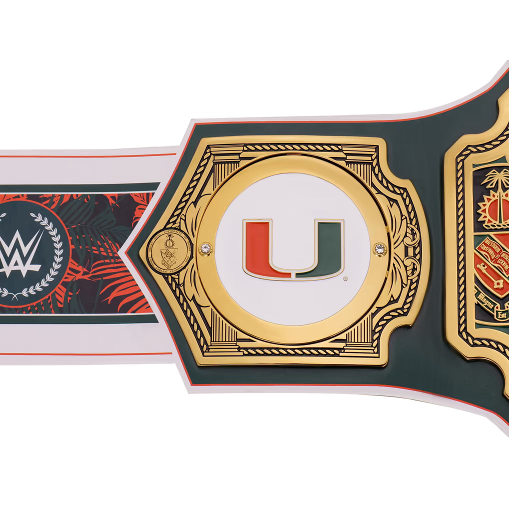 A close-up of a championship-style belt plate with a large gold-toned central frame, a white center, and a red-and-green U logo. Part of the strap shows a WWE logo on the left, and another decorative panel is visible on the right, all on a white background.