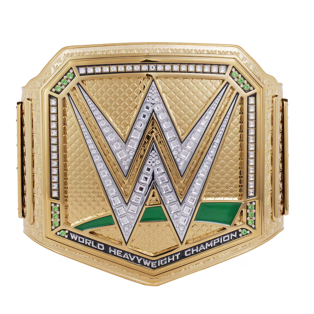 WWE World Heavyweight Championship belt in gold-tone metal with a large silver 'W' outlined in black, accented with clear stones, green enamel, and black lettering on a white background.