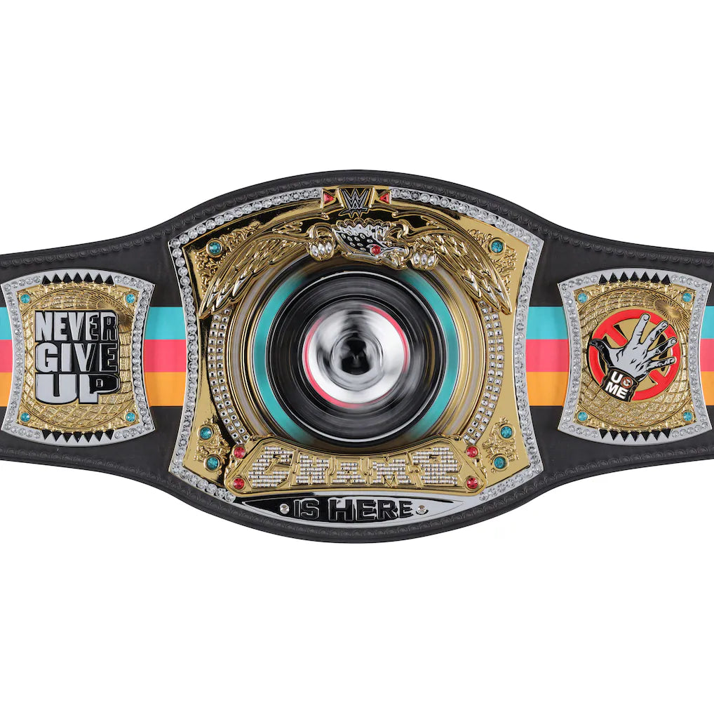 A highly detailed championship belt featuring a large central gold-toned winged medallion with a spinning black, silver, and red disc. The belt strap is black with turquoise, pink, and orange stripes, and includes two side plates with silver and gold designs and text reading 'NEVER GIVE UP' and 'U ME'.