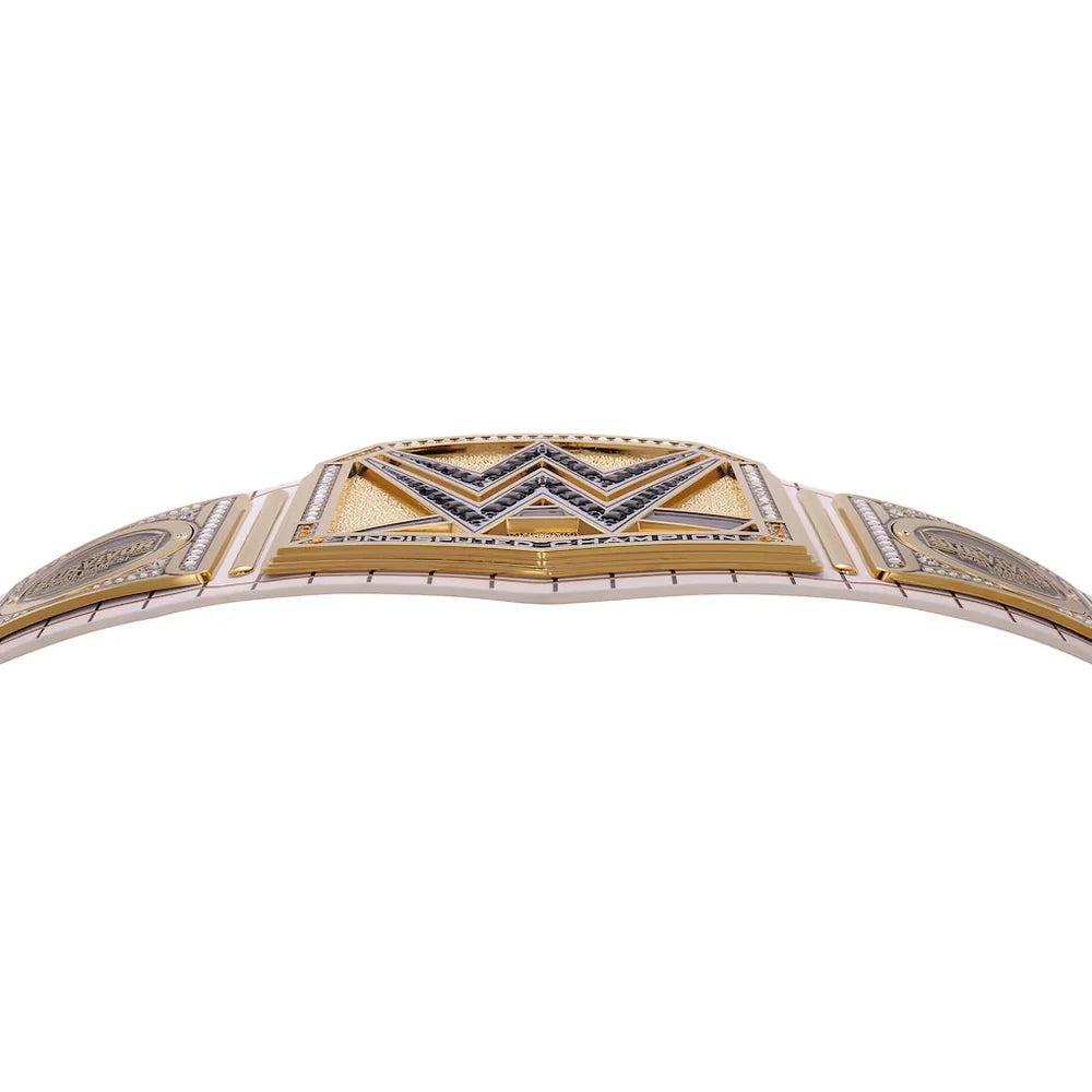 A close-up of a two-tone metal bracelet featuring a gold and silver-tone band with a central geometric diamond pattern embellished with small dark blue stones.
