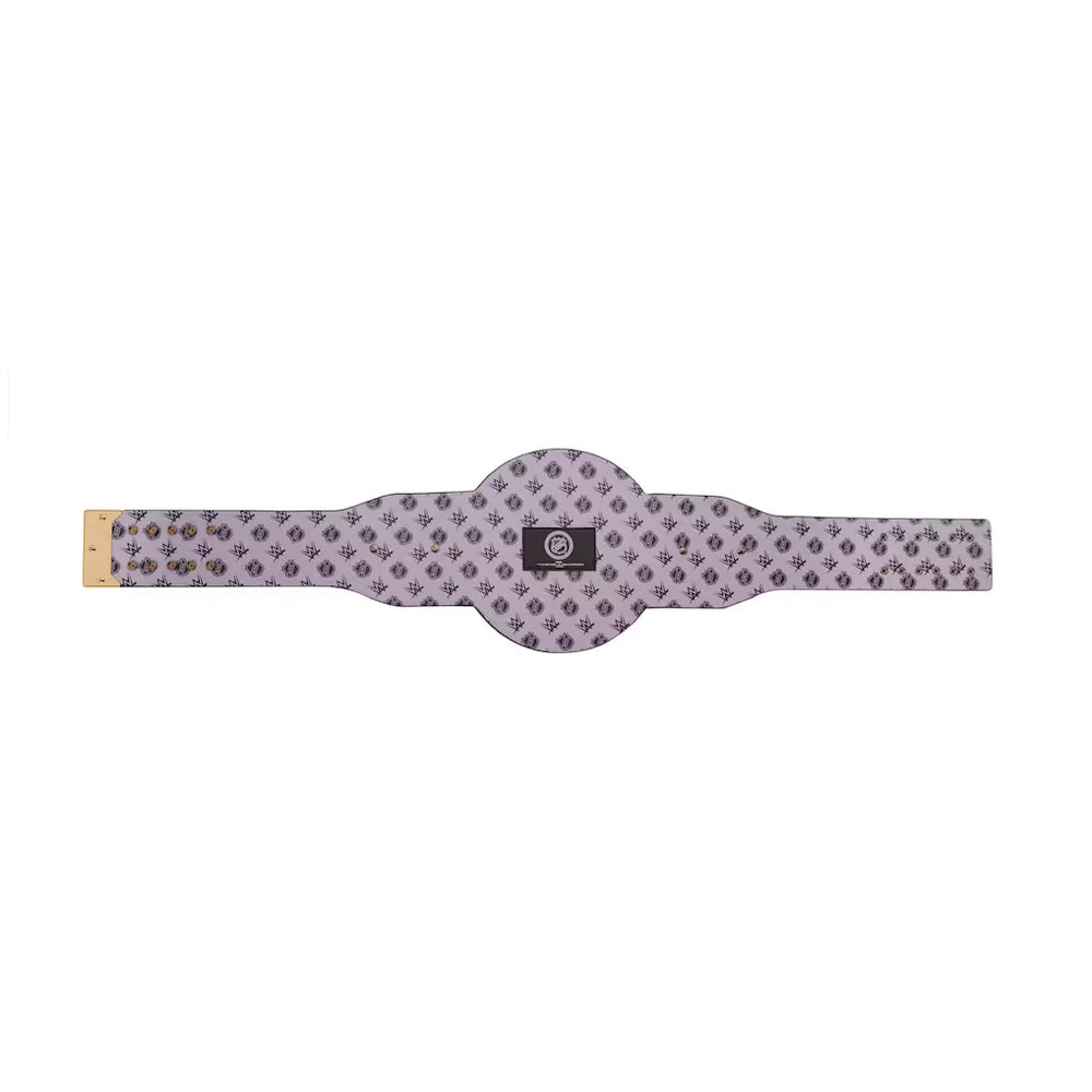 A wide, flat belt with a repeating geometric pattern in lavender and dark gray, featuring a central black label with a circular logo and a gold-toned metal tip on one end.