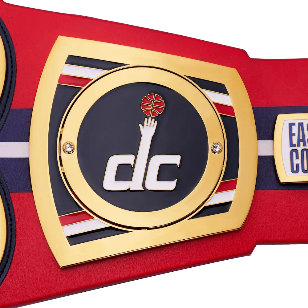 Close-up of a championship belt with a prominent logo and text on a red background