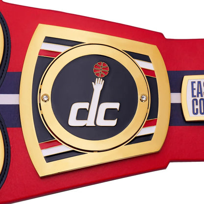 Close-up of a championship belt with a prominent logo and text on a red background