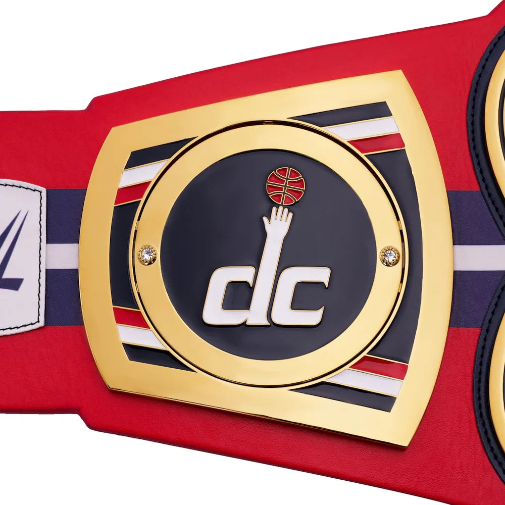Close-up of a championship belt with a prominent logo on a red background