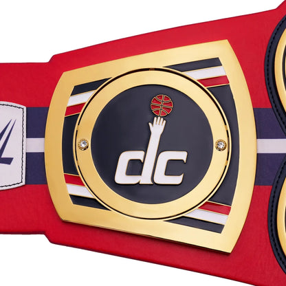 Close-up of a championship belt with a prominent logo on a red background