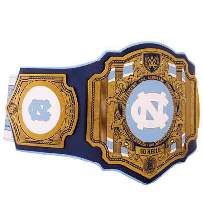 A replica of the UFC 148 North Carolina Tar Heels wrestling belt, featuring a navy blue strap with ornate gold-colored plates and light blue and white accents. The center plate displays the UNC Tar Heels logo, and the side plates feature matching gold and light blue designs.