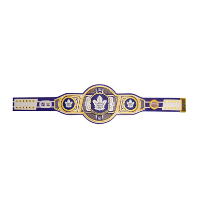 A championship belt featuring a central oval plate with a maple leaf emblem, flanked by two circular medallions and white sections on the strap, set against a plain white background.