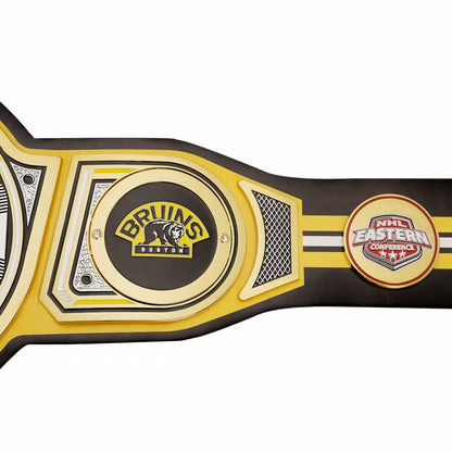 A close-up of a hockey championship belt featuring the Bruins Boston logo and an NHL Eastern Conference patch, shown on a plain white background.
