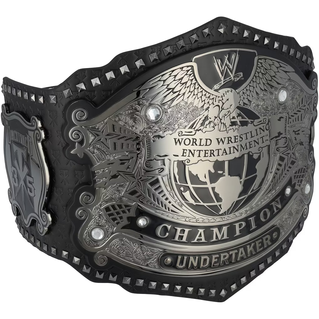 WWE World Wrestling Entertainment Undertaker Championship belt featuring a large silver-toned central plate with an eagle and globe design, black leather strap, and silver studs along the edges.