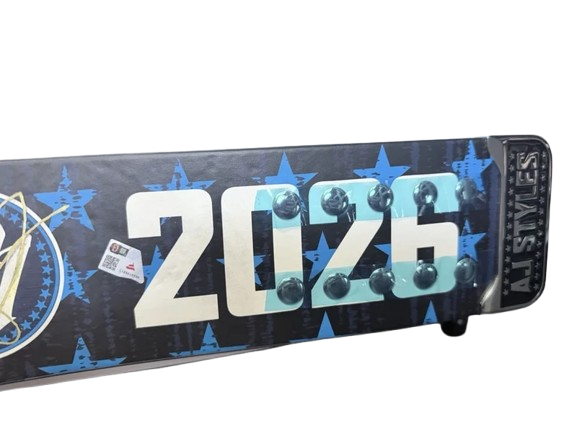 A custom snowboard featuring the year '2026' in large white and light blue letters, decorated with light bulbs, and blue star patterns on a black background. The brand 'AI STIVES' is visible on the tail.